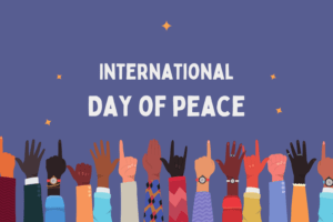 Hands of all colors and sizes making hand signs against a purple background. The graphic reads: “International Day of Peace.”